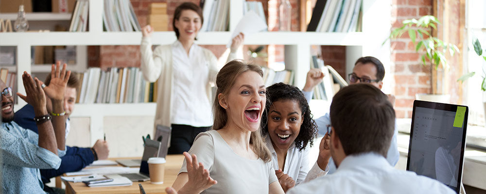 Casual work environment with team showing appreciation and validating a woman's presentation.